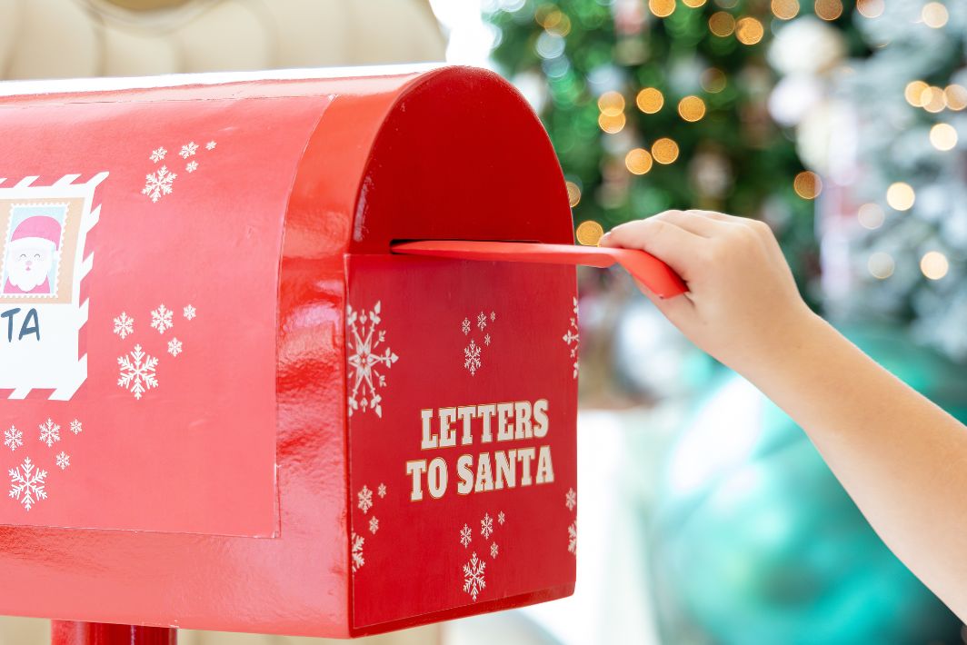 uma mão segurando uma carta em uma caixa de correio